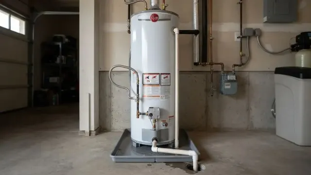 Gas tank water heater sitting on a drain pan in a garage utility corner